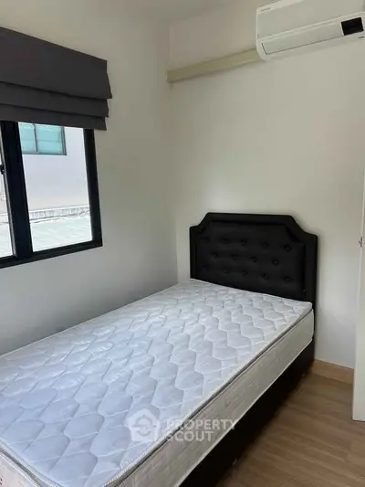 Cozy bedroom with single bed and air conditioning, perfect for a minimalist lifestyle.