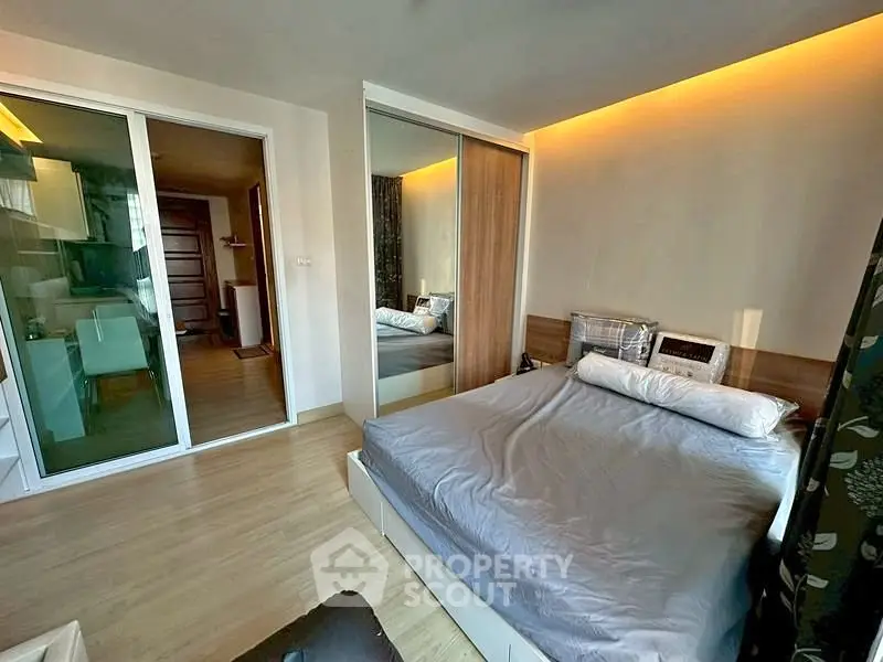Modern bedroom with mirrored closet and cozy lighting in a stylish apartment.
