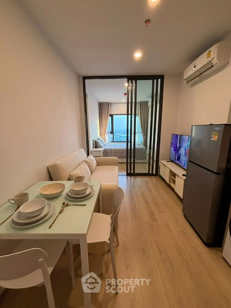 Modern open-plan living room with dining area and view of bedroom