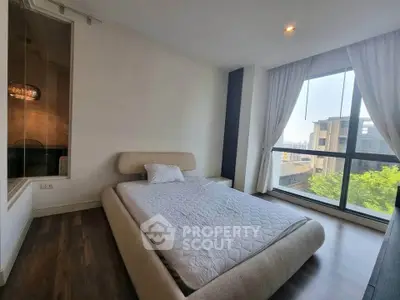 Spacious bedroom with modern design and large window offering a stunning view.