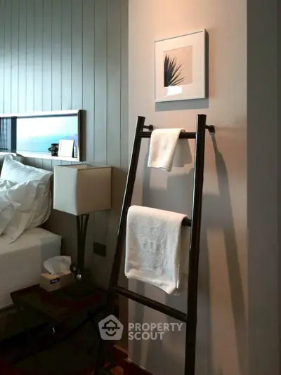 Stylish bedroom with modern decor and towel ladder