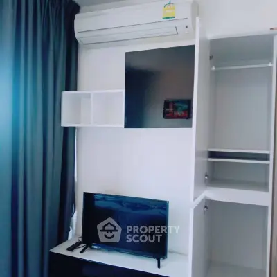 Modern living room with sleek TV setup and air conditioning unit