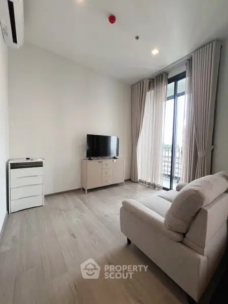 Modern living room with sleek furniture and large windows offering natural light.