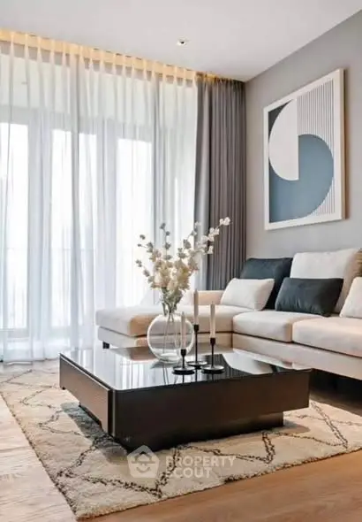 Elegant living room with modern decor, large windows, and stylish furniture.