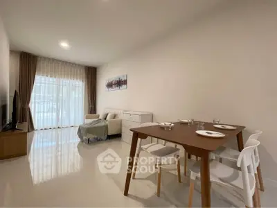 Spacious modern living room with dining area and large windows for natural light.