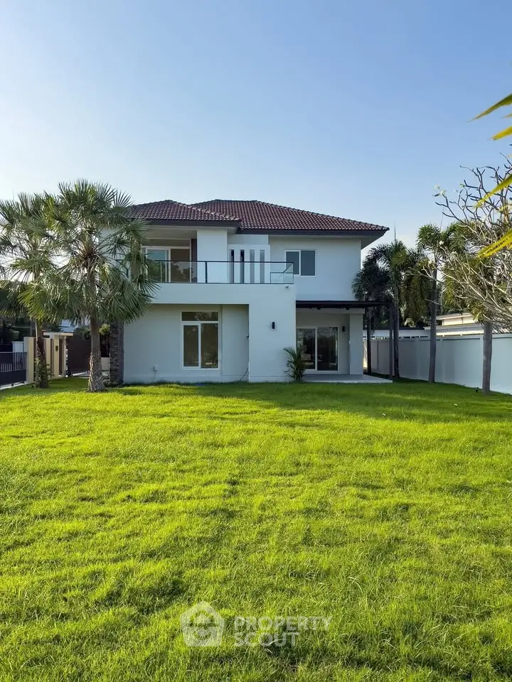 Stunning two-story house with lush green lawn and modern architecture.