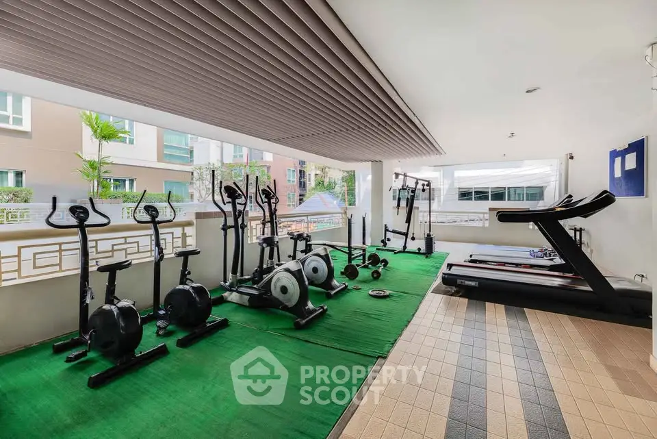 Modern gym area with exercise equipment in a residential building, featuring a bright and open layout.