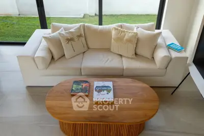 Stylish living room with modern white sofa and wooden coffee table, perfect for relaxation.