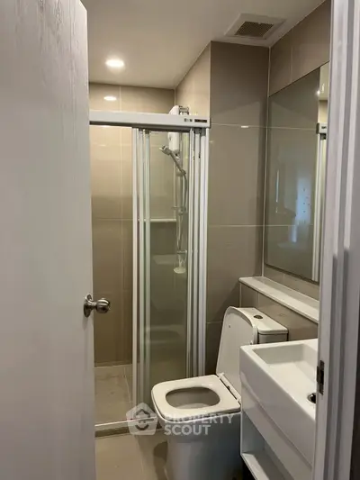 Modern bathroom with glass shower and sleek fixtures in a contemporary home.