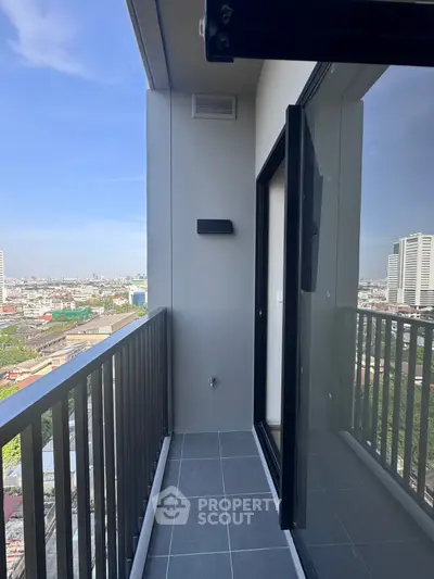 Modern high-rise balcony with city view and sleek glass door