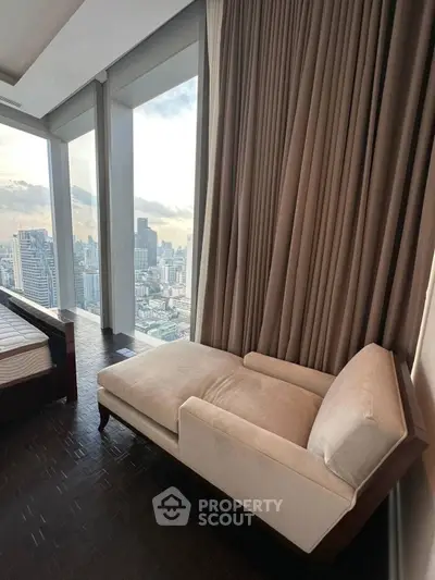 Luxurious bedroom with panoramic city view and elegant chaise lounge.