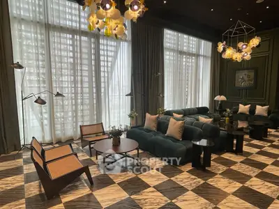 Luxurious living room with elegant decor and large windows, featuring stylish furniture and unique lighting fixtures.