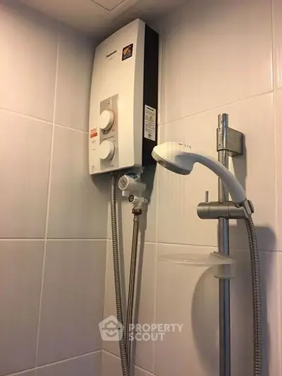 Modern bathroom with sleek shower unit and water heater installation.