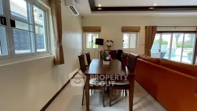 Spacious living room with elegant dining area and pool view, perfect for family gatherings.