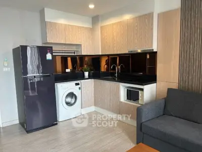 Modern kitchen with sleek appliances and cozy living area, perfect for urban living.