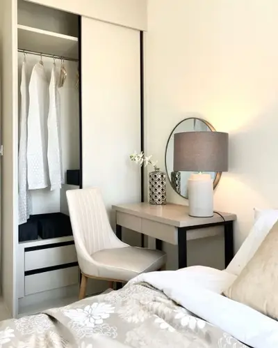 Elegant bedroom with stylish decor, featuring a cozy bed, chic chair, and modern wardrobe.