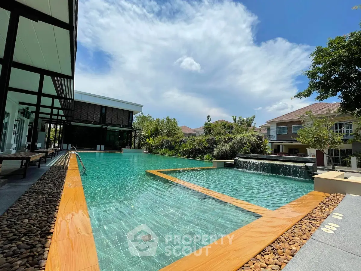 Luxurious outdoor pool area with modern design and lush greenery, perfect for relaxation and leisure.