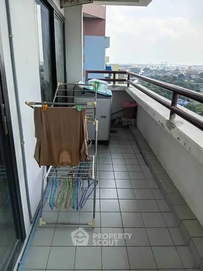 Spacious balcony with laundry area and city view, perfect for urban living.
