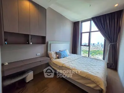 Modern bedroom with city view, featuring stylish decor and large window for natural light.