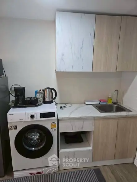 Modern compact kitchen with washing machine and sleek cabinetry