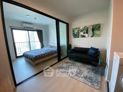 Modern apartment with cozy living room and stylish bedroom separated by glass wall, featuring chic decor.