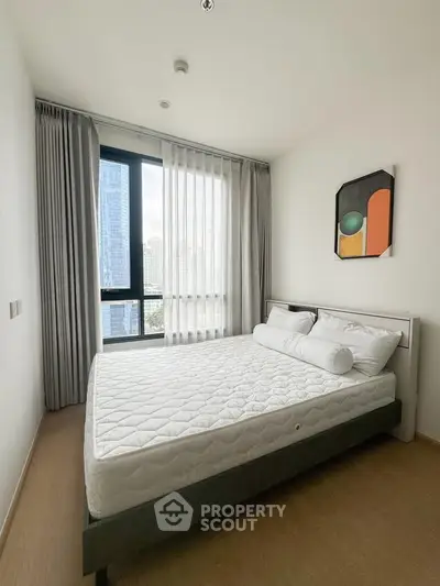 Modern bedroom with large window and stylish decor in a high-rise apartment.