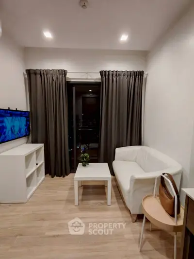 Modern living room with white sofa, TV, and balcony access.