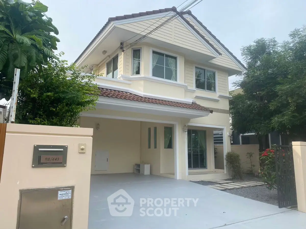 Charming two-story house with spacious driveway and lush greenery, perfect for family living.