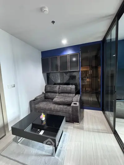 Modern living room with sleek furniture and glass partition in a stylish apartment.