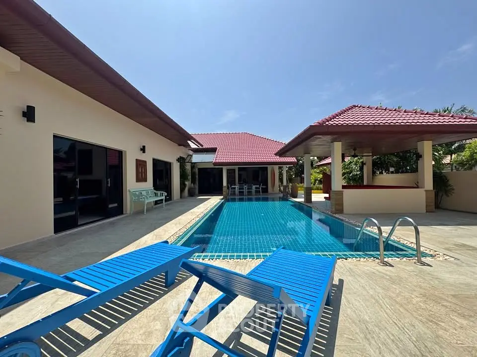 Luxurious villa with private pool and spacious patio under clear blue sky.
