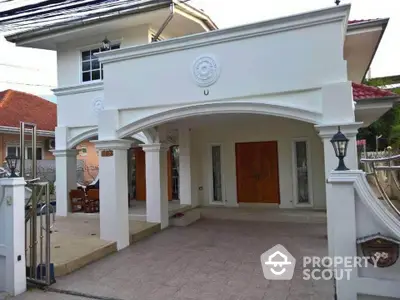 Elegant two-story house with classic white facade and wooden doors