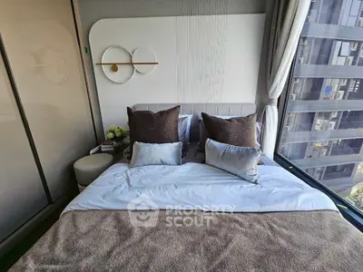 Luxurious bedroom with modern decor and large windows offering city views.