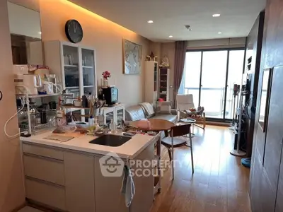 Modern open-layout living room with kitchen, wooden flooring, and balcony view.
