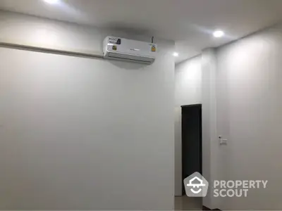 Minimalist interior with air conditioning unit and recessed lighting