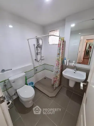 Modern bathroom with shower, toilet, and sink in a compact layout
