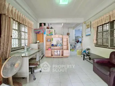 Spacious living room with tiled floor, large windows, and versatile furniture setup.