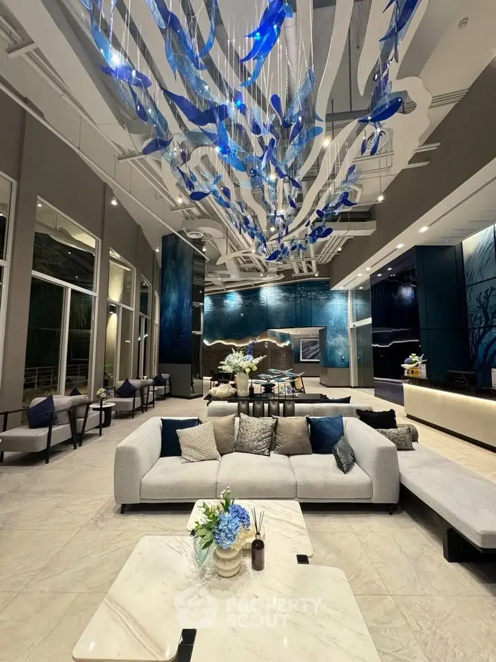 Luxurious modern lobby with elegant seating and stunning blue ceiling art installation.