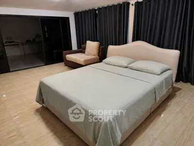 Spacious bedroom with elegant bed and cozy seating area, perfect for relaxation and comfort.