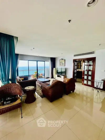 Spacious living room with ocean view, elegant furniture, and large windows in a luxury apartment.
