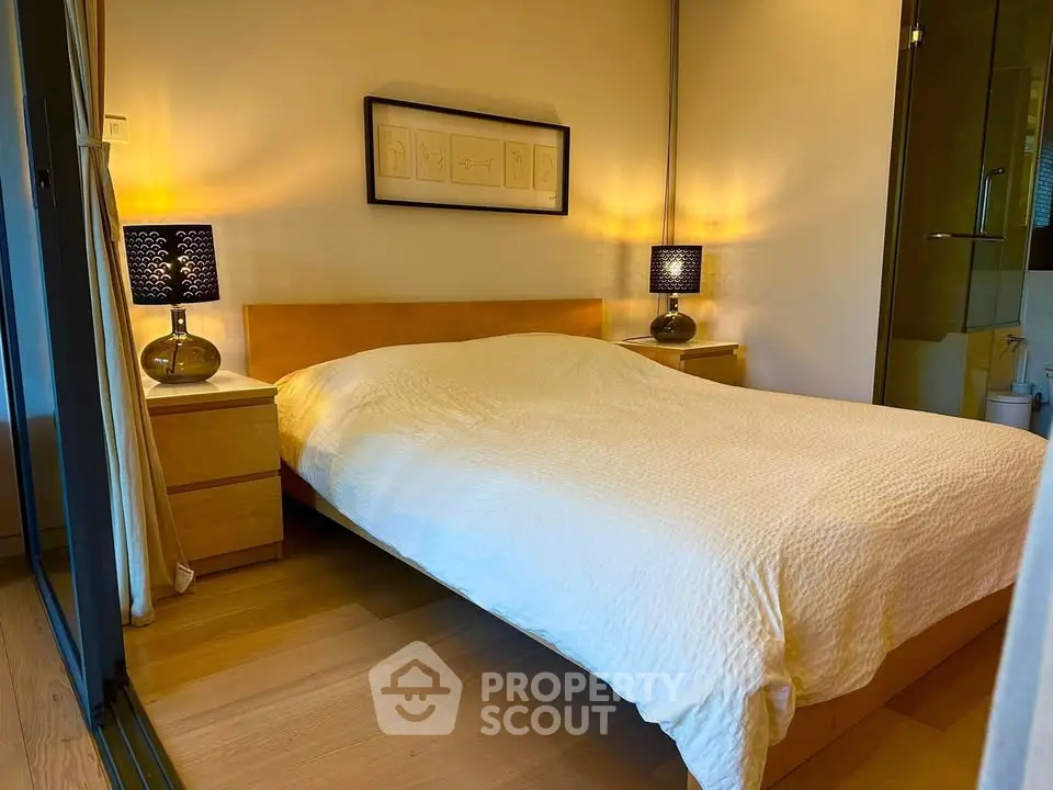 Cozy bedroom with modern decor and warm lighting, featuring a comfortable bed and stylish bedside lamps.