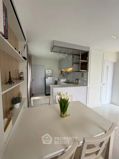 Charming kitchen with open layout and elegant dining area, featuring modern appliances and stylish decor.