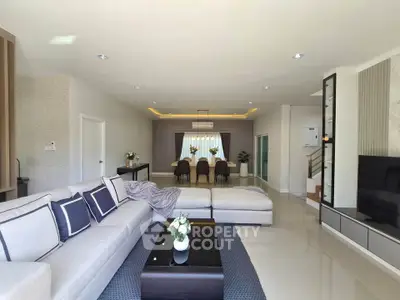 Spacious modern living room with elegant decor and ample natural light, perfect for family gatherings.