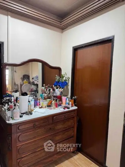 Charming bedroom with vintage wooden dresser and elegant decor accents.