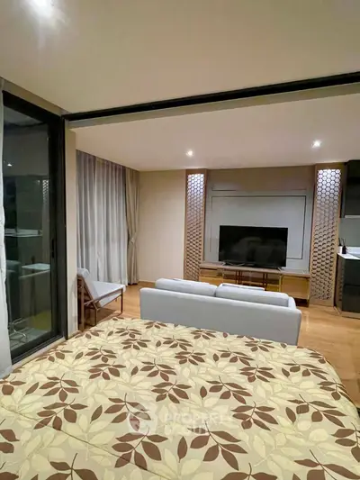 Modern living room with stylish decor and large TV, featuring a cozy seating area and elegant lighting.