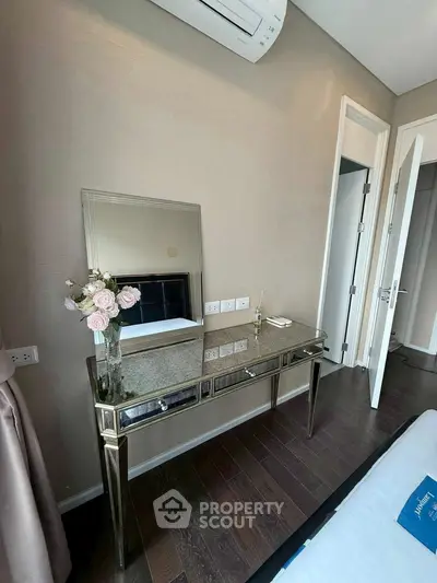 Elegant bedroom with mirrored vanity and air conditioning, showcasing modern interior design.