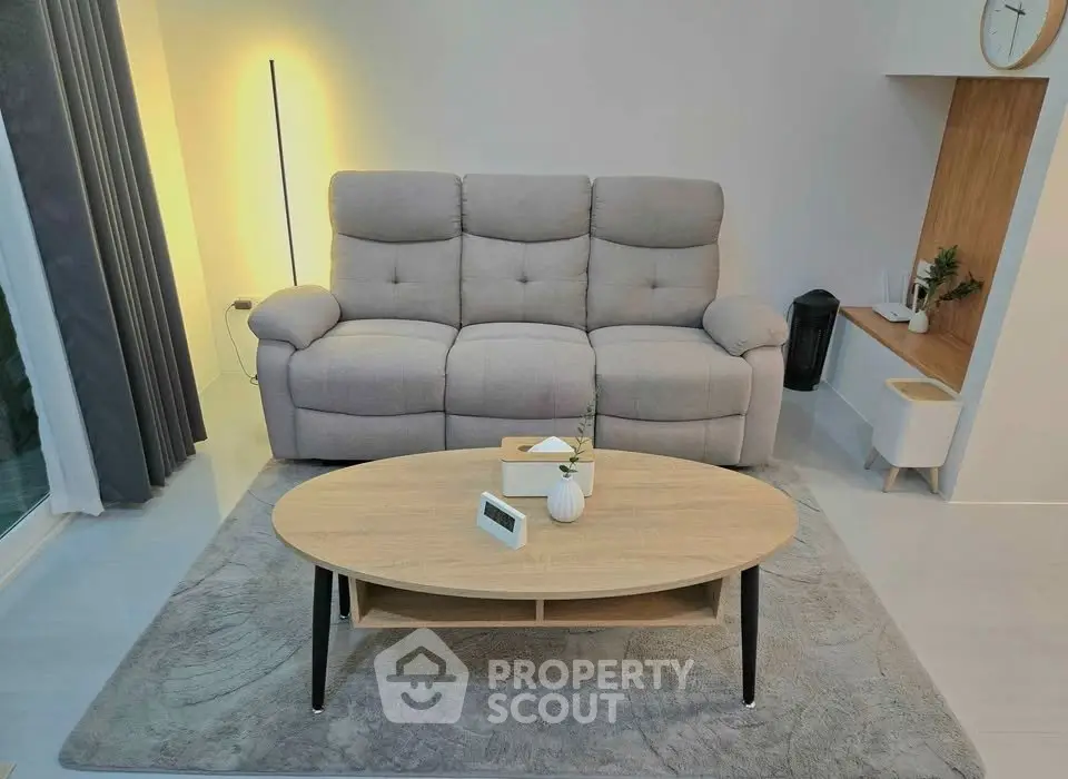 Modern living room with cozy sofa and stylish coffee table on a plush rug, perfect for relaxation.