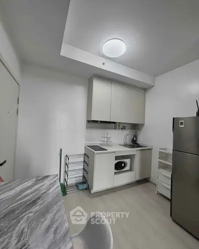 Modern compact kitchen with sleek appliances and minimalist design, perfect for urban living.