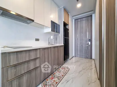 Modern kitchen with sleek cabinetry and marble flooring in a stylish apartment.