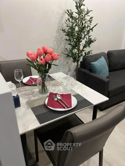 Chic dining area with elegant table setting and cozy seating in modern apartment.