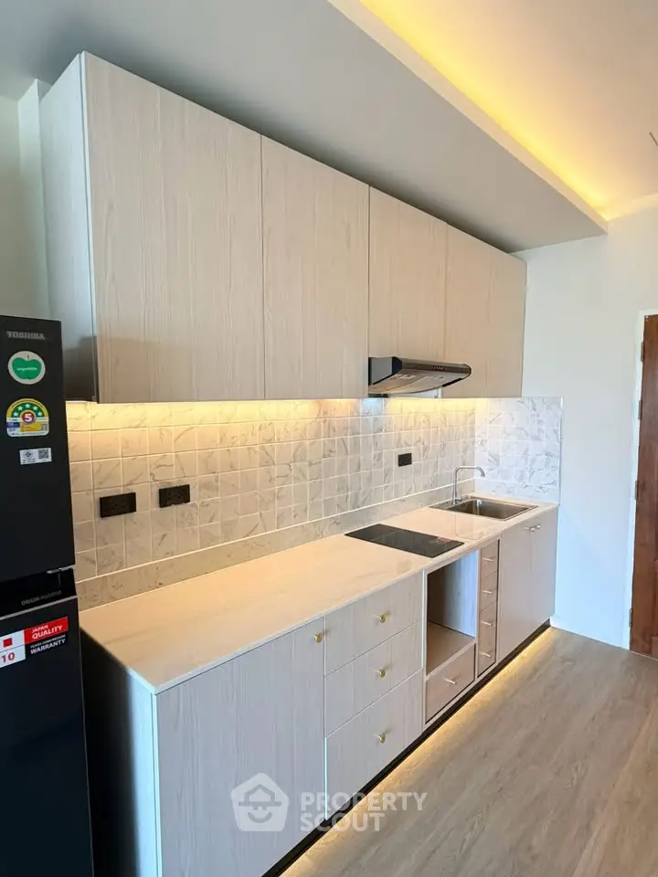 Modern kitchen with sleek cabinetry and under-cabinet lighting, featuring a minimalist design and ample storage space.